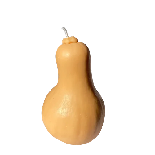 Realistic butternut squash shaped candle in natural tan and cream tones
