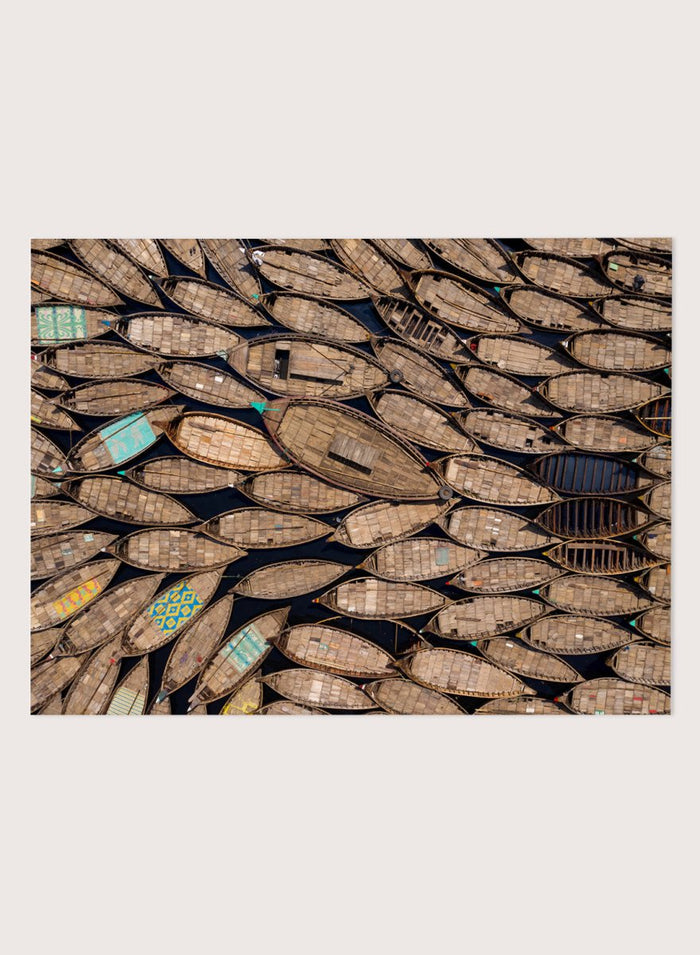 Framed artwork of a pattern made from wooden boats. Wooden Boats by Azim Khan Ronnie aerial photography print showing clustered wooden boats from above, textured pattern wall art poster