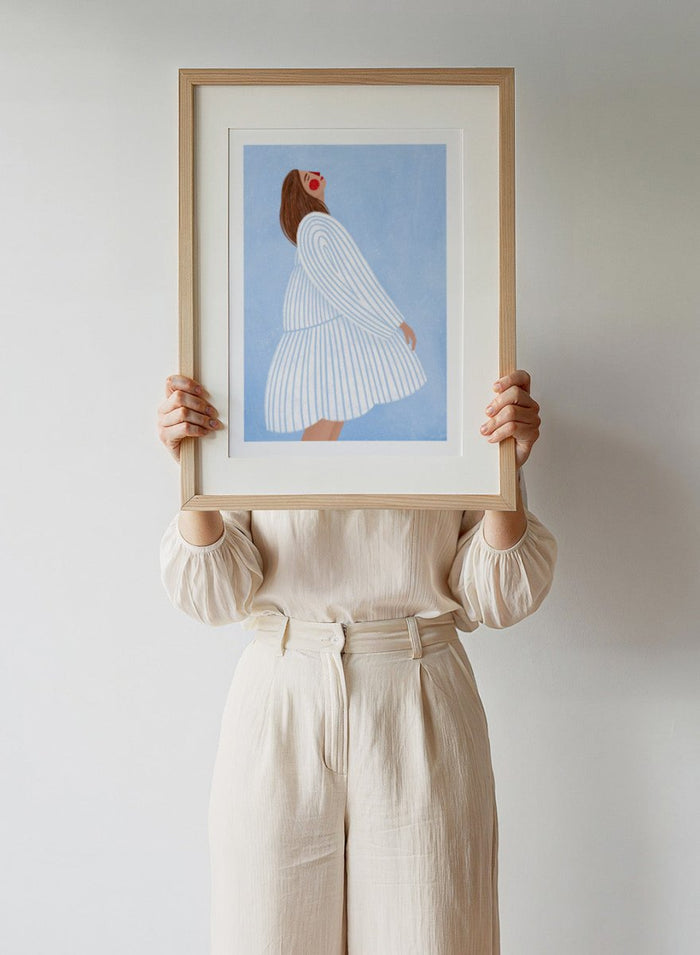 The Woman With the Blue Stripes by Bea Müller is an officially licensed art print featuring soft blue tones and a flowing modern portrait. Framed or unframed options available.