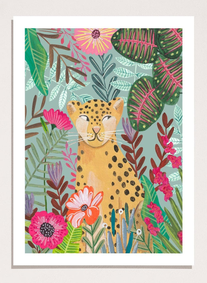 Illustration of a cheetah surrounded by colorful flowers and leaves on a light blue background. Happy Leopard Tropical Flowers by Caroline Bonne Müller is a fine art print and wall poster featuring a leopard with tropical flowers in a modern aesthetic style.