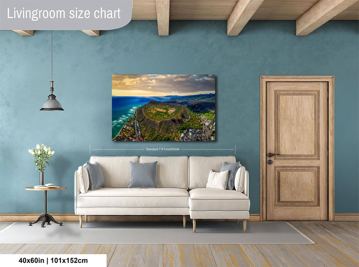 a living room with a large wall-mounted painting depicting a scenic coastal landscape. The painting is framed and hangs above a white sofa, which is positioned in front of a wooden door. The room has a wooden floor and a small table with a vase of flowers. The wall has a blue color, and the overall layout and design of the room create a cozy and inviting atmosphere.