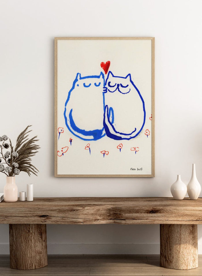 Two blue cats holding a red heart with small colorful flowers around on a white background. Lovin’ Cats by Eden Kalif is a modern cat art print with two figures and a red heart, a contemporary minimalist wall poster with playful form and expressive line work.