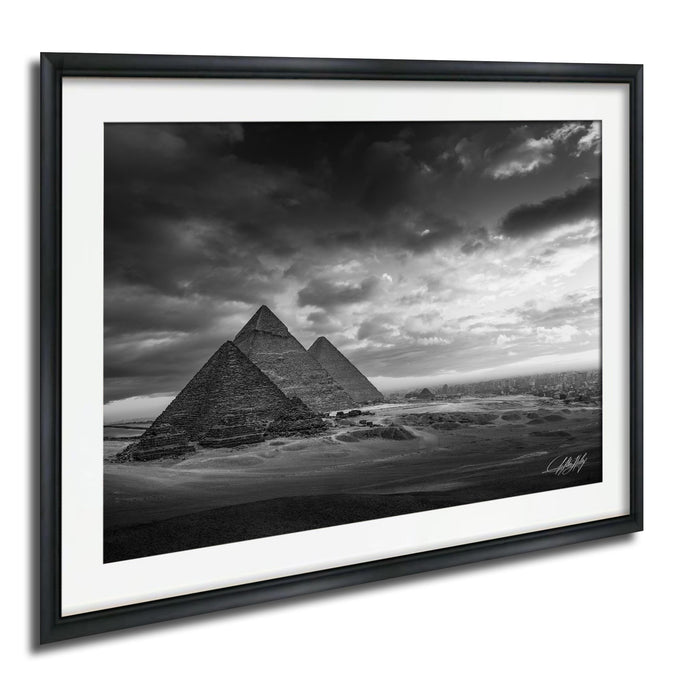 the iconic pyramids of Giza, Egypt, standing majestically against a dramatic cloudy sky.