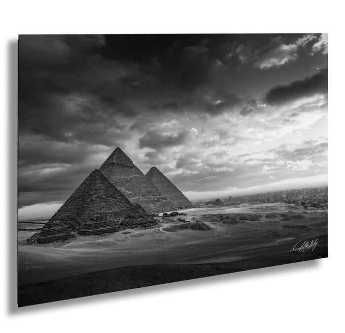 the iconic pyramids of Giza, Egypt, standing majestically against a dramatic cloudy sky.
