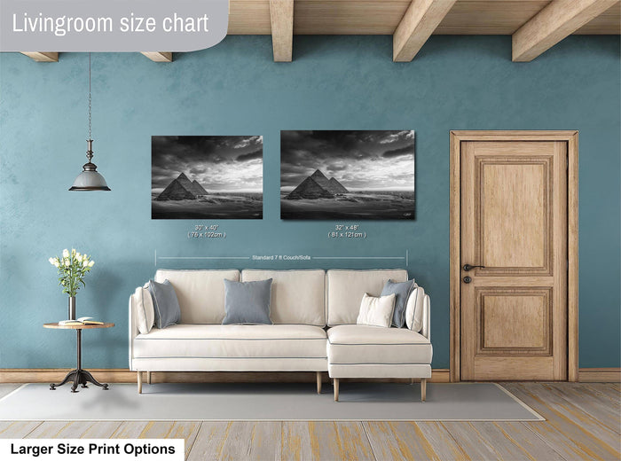 a living room with a white sofa, a wooden door, and a painting of the pyramids on the wall.