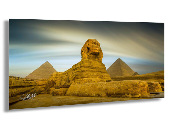 the Great Sphinx of Giza, a large limestone statue of a mythical creature, standing in the foreground with the pyramids of Giza in the background.