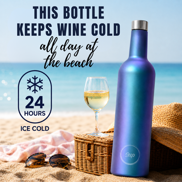 A blue-to-purple iridescent insulated wine bottle stands on a sandy beach next to a glass of white wine, sunglasses, a wicker basket, and a straw hat, with promotional text reading 'THIS BOTTLE KEEPS WINE COLD all day at the beach' and '24 HOURS ICE COLD'.