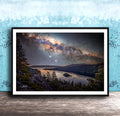 The image is a framed photograph depicting a serene night scene with a lake, mountains, and a starry sky.