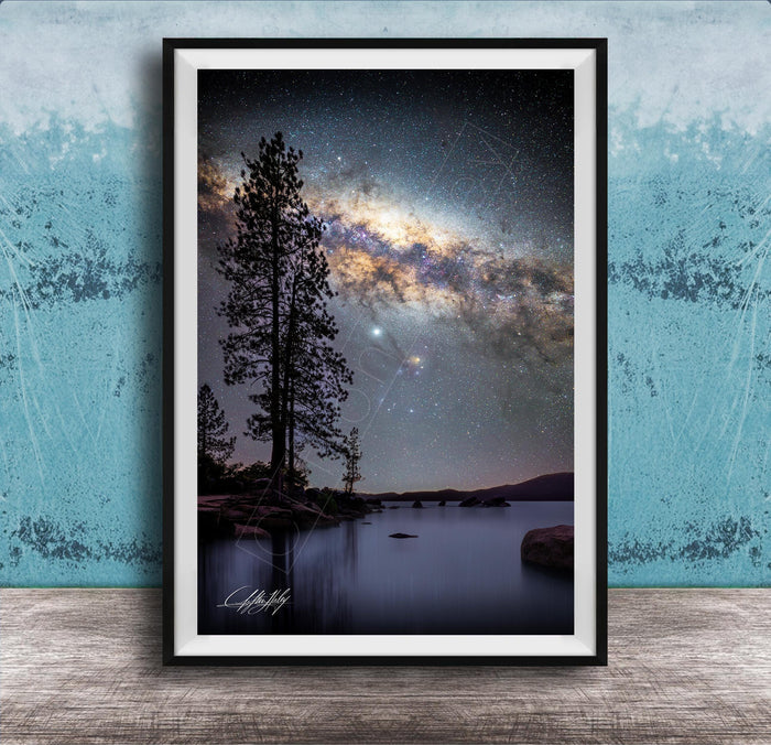 The image is a framed photograph of a serene night scene with a starry sky, a lake, and a forest.