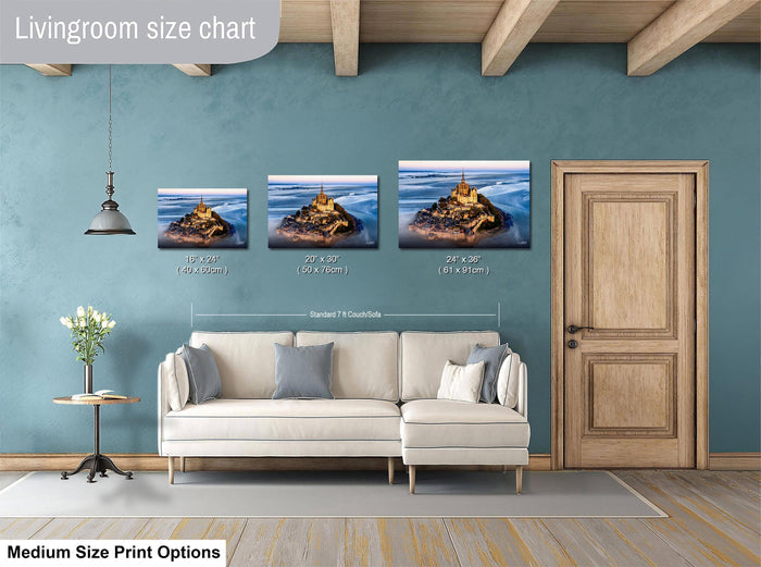 a living room with a white sofa and a wooden door. Above the sofa, there is a livingroom size chart that provides the dimensions of three framed landscape photographs in inches. The chart indicates that the largest photograph is 24 inches wide and the smallest is 18 inches wide. The medium-size print options are not described, and the image is not a collage of multiple images.