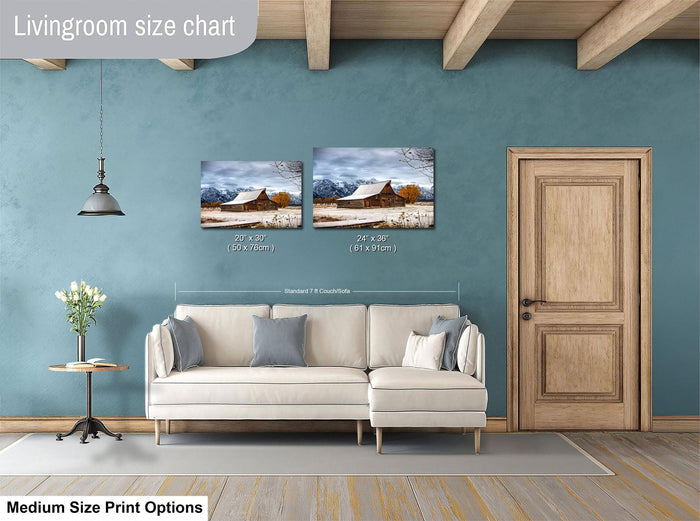 a living room with a white sofa, a wooden door, and a painting of a snowy landscape on the wall. The living room appears to be designed for relaxation and comfort, with a cozy and inviting atmosphere.