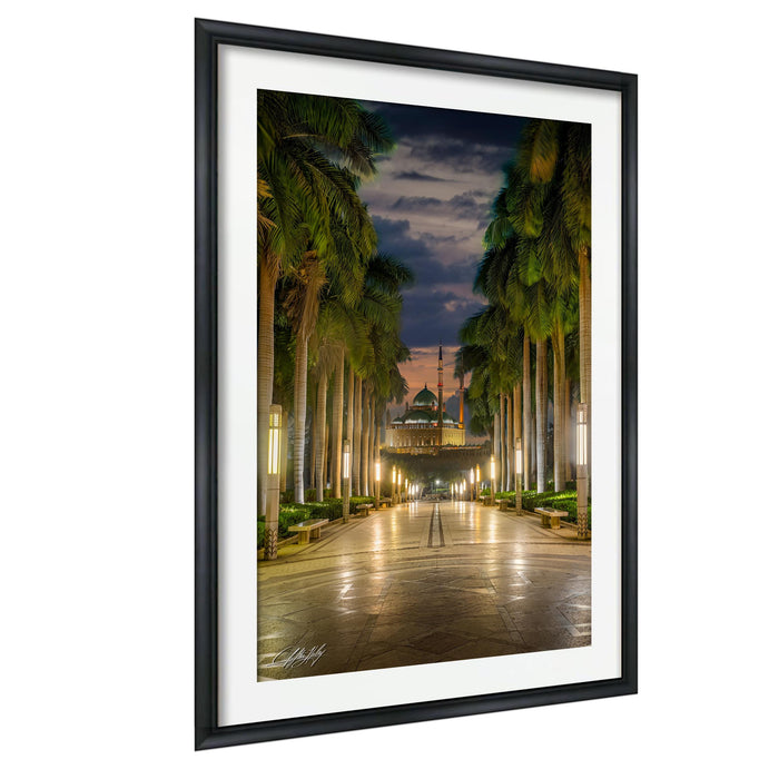 a serene and picturesque scene of a long, illuminated walkway lined with palm trees, leading towards a mosque in the distance. The warm glow of the lights and the silhouettes of the palm trees create a tranquil atmosphere, inviting viewers to imagine themselves strolling down the path.