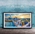 A framed painting depicting a cityscape with a bridge, buildings, and a river, set against a blue sky with a sunset.