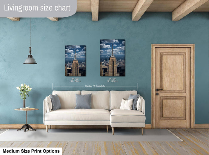a living room with a white sofa, a wooden door, and a framed picture of the Empire State Building on the wall.