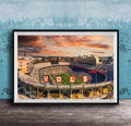 A framed photograph of a sports stadium with the word "VOLS" prominently displayed, set against a backdrop of a colorful sunset sky.