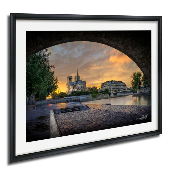 a picturesque view of a cityscape, with a large cathedral in the background and a bridge arching over a river in the foreground. The sky is filled with warm, vibrant colors, creating a serene and peaceful atmosphere.