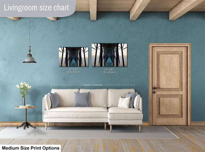 a living room with a white sofa, a wooden door, and a wooden beam ceiling. There are two framed pictures hanging on the wall, one of a bridge and the other of a building. The living room appears to be well-lit and has a modern design.