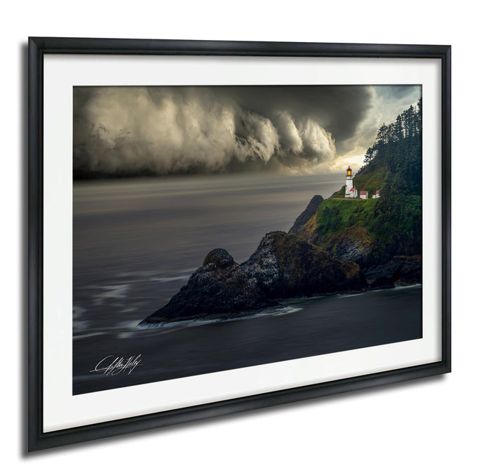 A framed photograph depicting a lighthouse on a rocky coastline, with a stormy sky and crashing waves in the background.