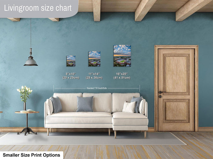 a living room with a white sofa, a wooden door, and a hanging light fixture. There are three framed landscape paintings of varying sizes displayed on the wall, with the largest one being 11 x 14 inches and the smallest one being 8 x 10 inches.