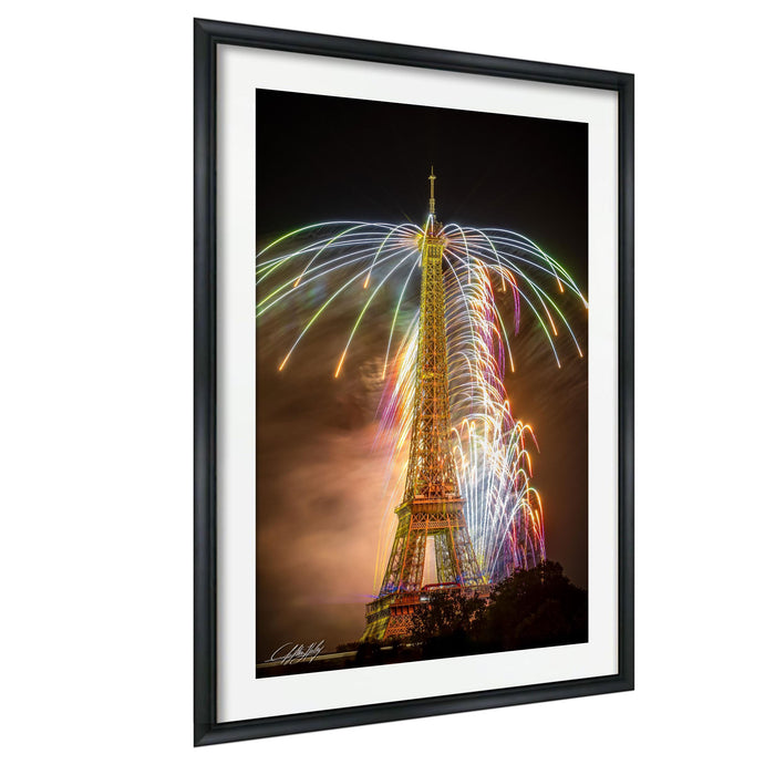 a tall tower with a large, colorful fireworks display lighting up the night sky behind it.
