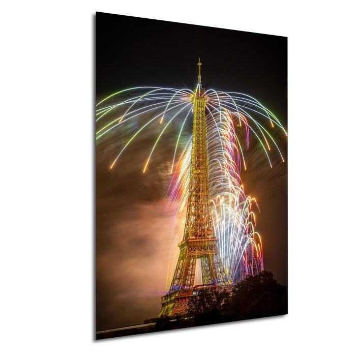 a tall tower with a large, colorful fireworks display lighting up the night sky behind it.