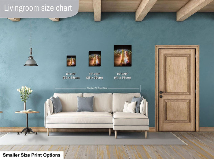 a living room with a white sofa, a wooden door, and a hanging light fixture. There are three framed artworks displayed on the wall, each with a different size and frame. The living room appears to be well-decorated and spacious.