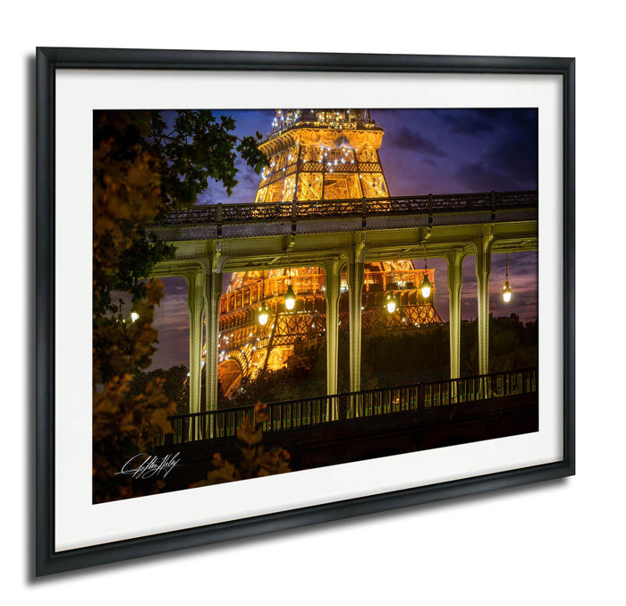a nighttime view of the Eiffel Tower in Paris, France, with its intricate iron lattice structure illuminated against the dark sky.