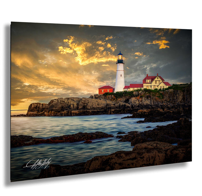 A picturesque lighthouse stands on a rocky shore, overlooking the calm ocean at sunset.