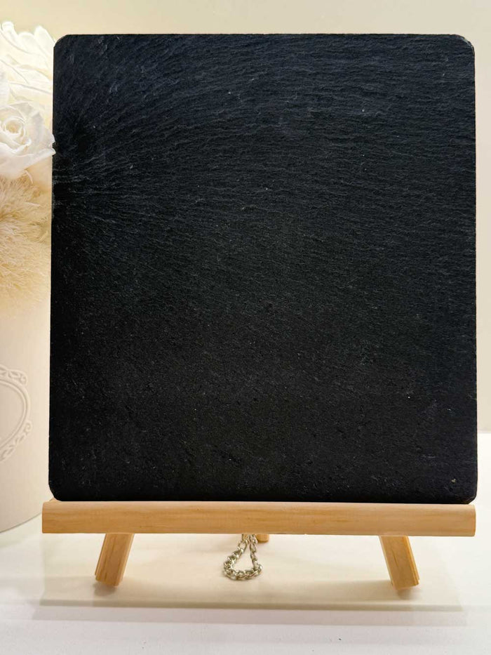 Personalized slate sign propped on a wooden easel with engraved custom message