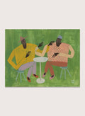 Framed artwork of two people sitting at a table on a green background. In Good Company by Studio IMO (Ibi Meier-Oruitemeka) is a modern figurative art print featuring two figures at a table in a bold contemporary wall poster design.