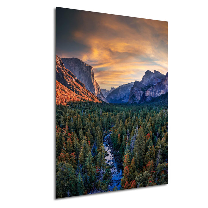 a breathtaking mountainous landscape with a winding river flowing through a dense forest. The sky is filled with vibrant colors, creating a stunning backdrop for the natural scenery.